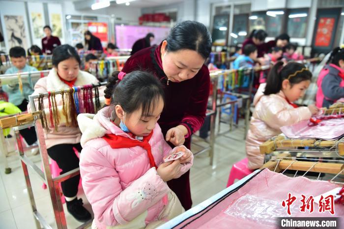 江西省級非遺豫章繡傳承人手把手指導(dǎo)小學(xué)生繡制2022年北京冬奧會吉祥物“冰墩墩”形象?！∮髟屏?攝