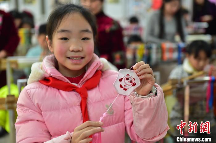 圖為一名小學(xué)生繡制的2022年北京冬奧會吉祥物“冰墩墩”形象?！∮髟屏?攝
