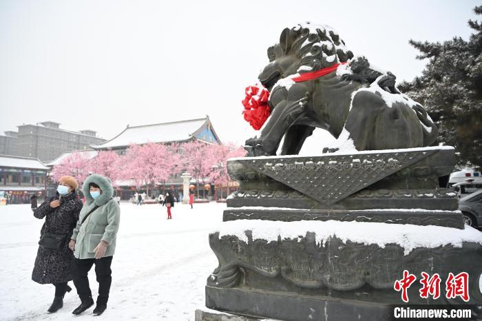 2月13日，民眾在呼和浩特市大召廣場雪中漫步?！⑽娜A 攝