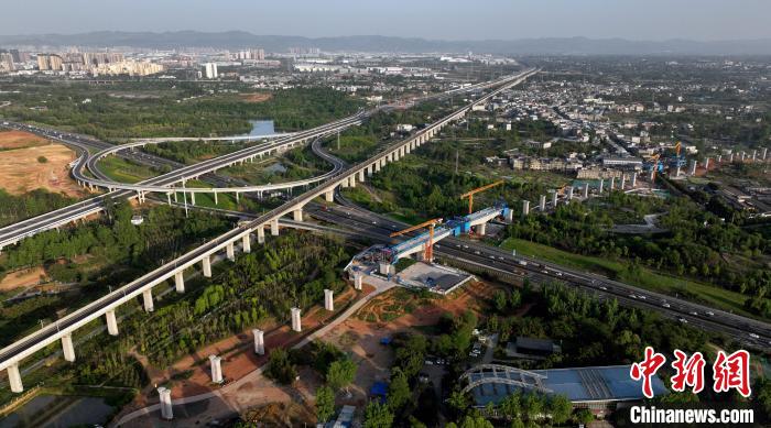 航拍正在建設(shè)的跨越成都繞城高速公路連續(xù)梁施工現(xiàn)場，旁邊依次為已運營的成渝高速鐵路和機場高速公路?！⒅铱?攝