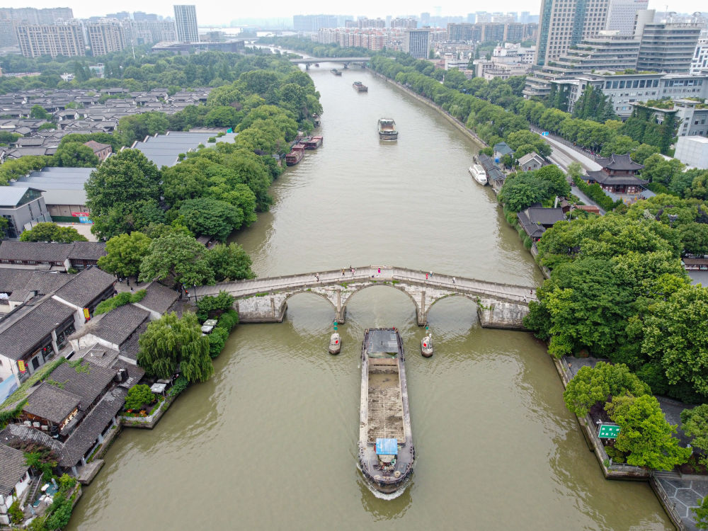 5月27日，一艘貨船駛過京杭大運河南端標志建筑杭州拱宸橋。(無人機照片)新華社記者江漢 攝