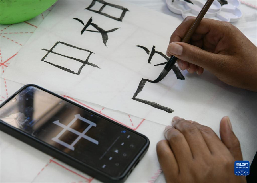 4月18日，肯尼亞學生在內(nèi)羅畢大學孔子學院舉辦的活動上寫毛筆字?？夏醽唭?nèi)羅畢大學孔子學院18日舉辦“中文，增進文明對話”主題活動，慶祝即將到來的第14個聯(lián)合國中文日?？夏醽唽W生參與互動，進行書法、剪紙、唱中文歌等活動。新華社記者 韓旭 攝