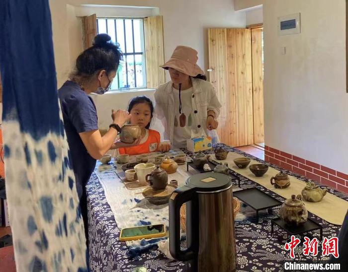 圖為：游客正在咨詢臺(tái)灣柴燒作品?！∪~秋云 攝