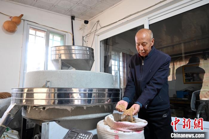 李家莊村民谷文朝重拾父輩的手藝，做起石磨面粉的營生?！〉杂鸺?攝