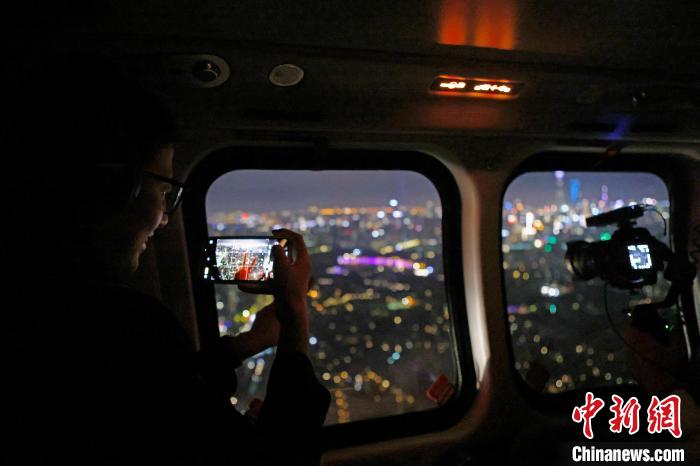 6月3日晚，游客乘坐上海新空直升機(jī)有限公司直升機(jī)開(kāi)啟鳥(niǎo)瞰黃浦江空中圓夢(mèng)之旅，并用手機(jī)拍攝城市夜景?！∫罅⑶?攝