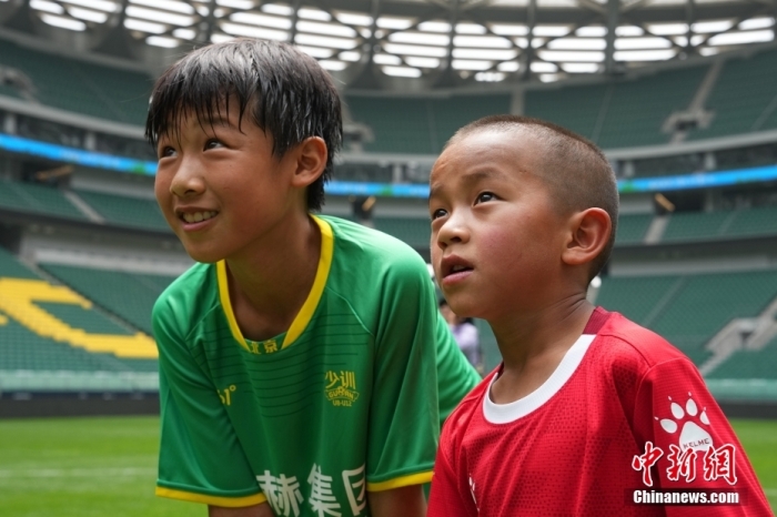 圖為北京國(guó)安小球員陳小北和7歲的俄金仁增在一起觀看場(chǎng)內(nèi)播放的紀(jì)錄片。<a target='_blank' href='/' _fcksavedurl='/'><p  align=