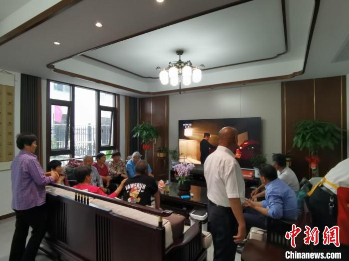 親友們集中在費(fèi)俊龍家中觀看返程的視頻?！＄娚?攝