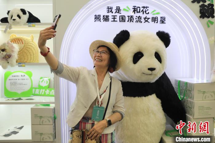 美國華視總裁楊蓮花與大熊貓文創(chuàng)產(chǎn)品合影?！⊥趵?攝