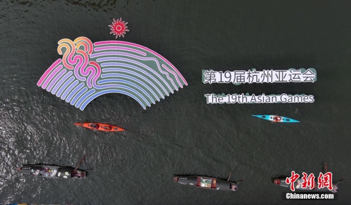 資料圖為烏篷船和皮劃艇從杭州亞運會標識前劃過。王剛 攝