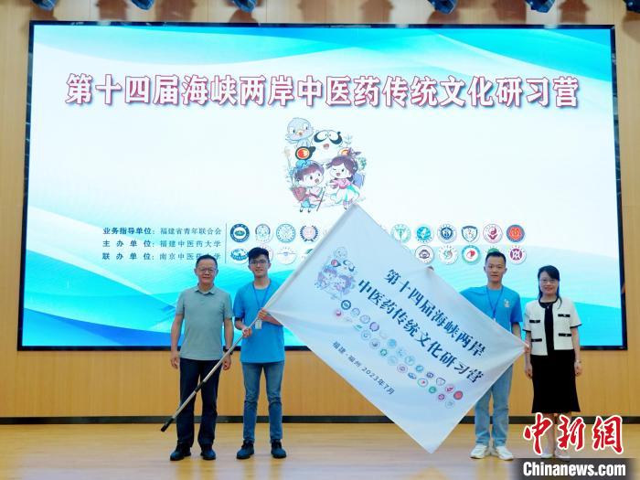 共青團(tuán)福建省委副書記吳雪(右一)、福建中醫(yī)藥大學(xué)黨委副書記林羽(左一)為兩岸學(xué)生代表頒授營(yíng)旗?！≡S燁婷 攝