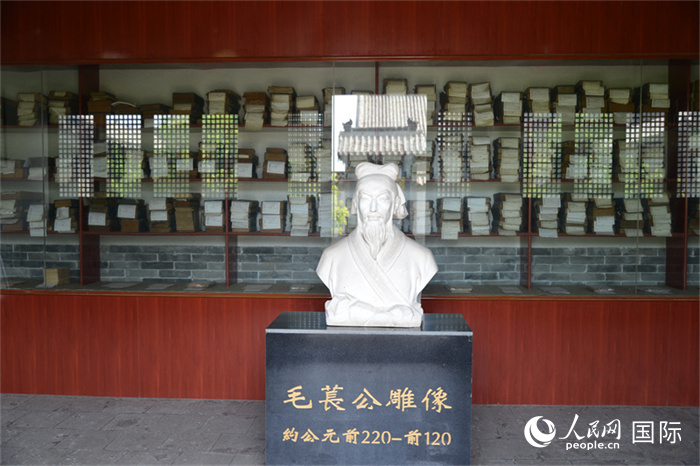 河間詩(shī)經(jīng)齋毛萇雕像。雕像后書(shū)櫥中陳列的是歷代各版本《詩(shī)經(jīng)》及譯本。 人民網(wǎng) 趙昭攝