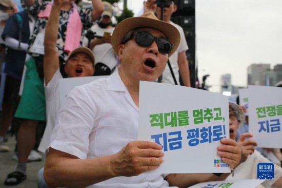 7月22日，在韓國首爾，人們手舉標(biāo)語參與反戰(zhàn)游行。新華社發(fā)（楊暢 攝）