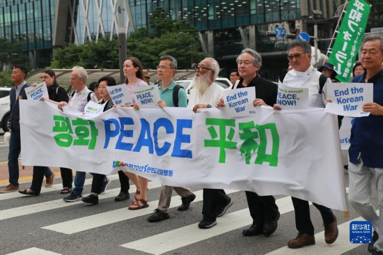 7月22日，在韓國首爾，人們手舉標(biāo)語參與反戰(zhàn)游行。新華社發(fā)（楊暢 攝）