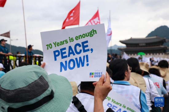 7月22日，在韓國首爾，人們手舉標(biāo)語參與反戰(zhàn)游行。新華社發(fā)（楊暢 攝）