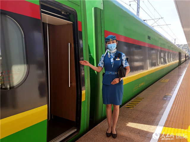趙瑩靜站在“復(fù)興號(hào)”國際旅客列車車廂門口歡迎旅客上車。人民網(wǎng) 杜明明攝