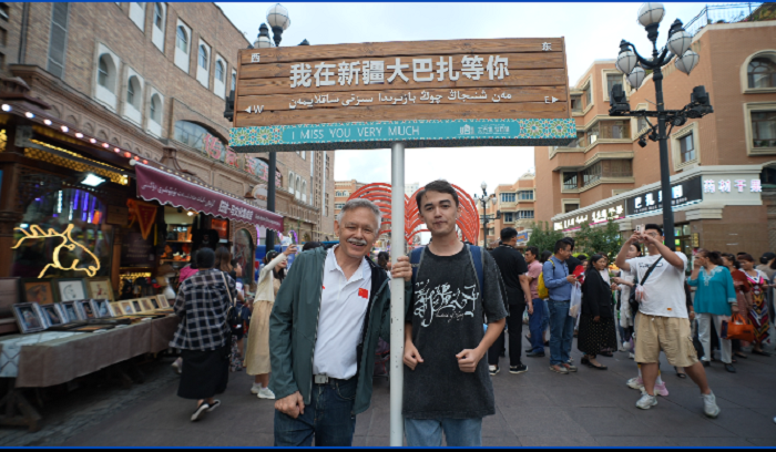 潘維廉和維吾爾族青年伊木蘭“打卡”大巴扎。主辦方供圖