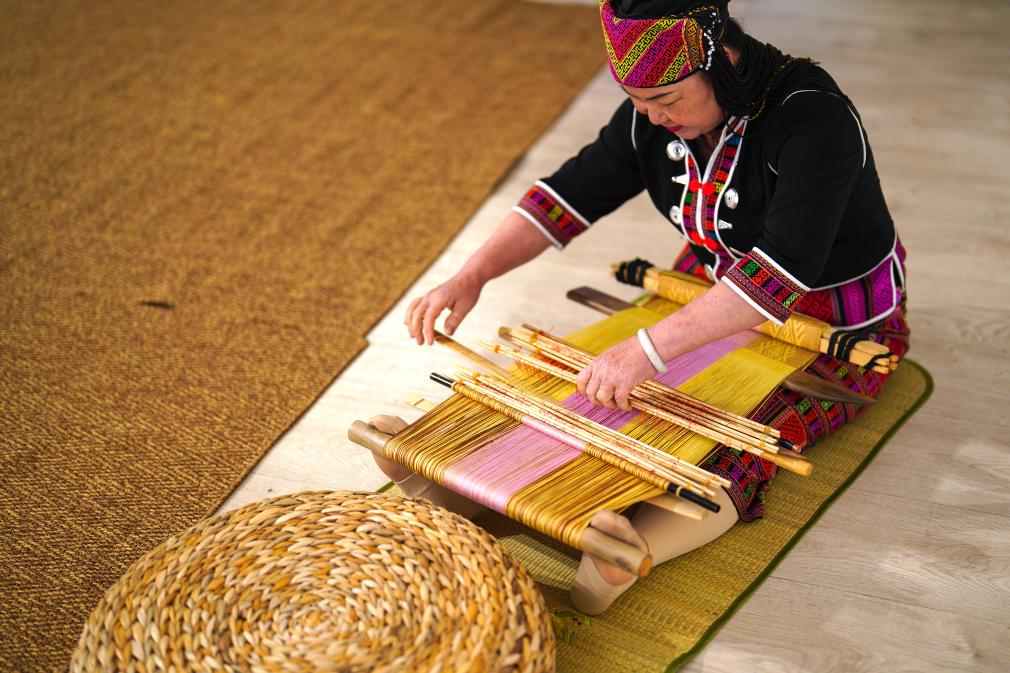 4月17日，黎族傳統(tǒng)紡染織繡技藝國家級代表性傳承人劉香蘭在2023年意大利米蘭設計周上展示黎錦織造技藝。新華社發(fā)