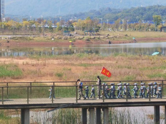 　　10月24日，秋游的幼兒園小朋友在老師帶領(lǐng)下走在清水塘公園里的木橋上。本報(bào)記者 常雯宜攝