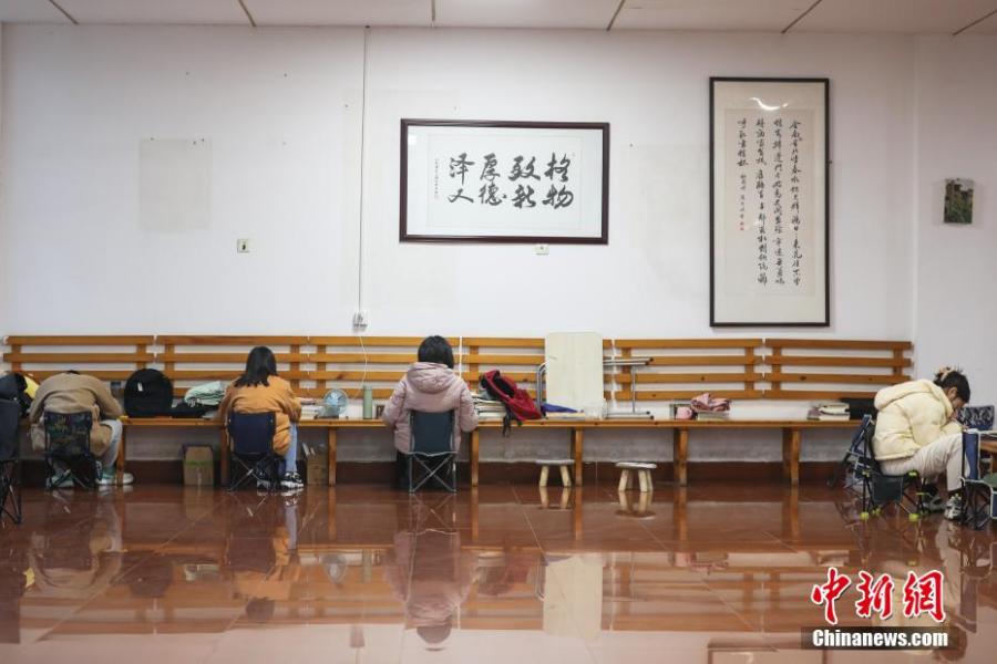 資料圖：幾位考研學(xué)生在南昌大學(xué)教學(xué)樓的公共空間復(fù)習(xí)備考。劉力鑫 攝