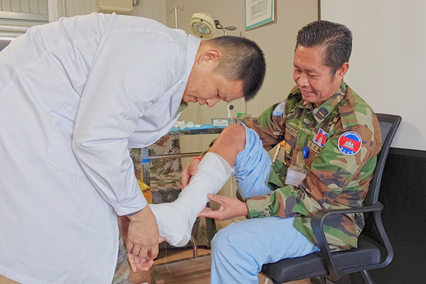 中國第22批赴黎維和醫(yī)療分隊軍醫(yī)為患者打石膏固定患肢。李清竹攝