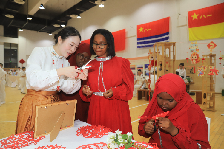 中國剪紙藝術吸引當?shù)厝耸繀⑴c體驗。陳錦俊攝