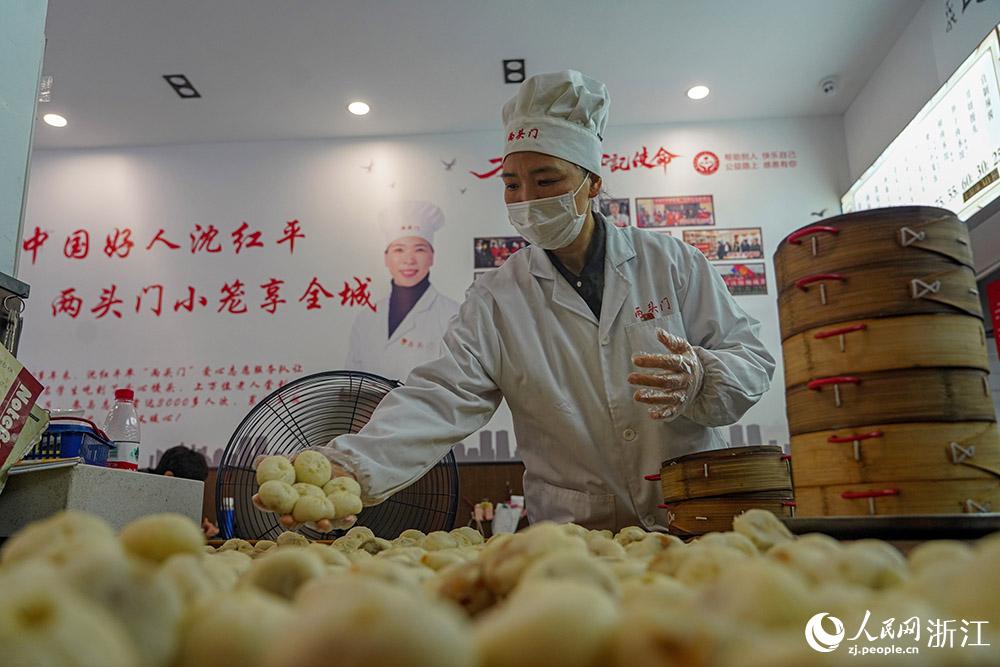 3月31日，在浙江省嵊州市甘霖鎮(zhèn)，嵊州小吃從業(yè)者沈紅平把蒸熟的小籠包晾涼，打包冷藏售賣。人民網(wǎng) 章勇濤攝