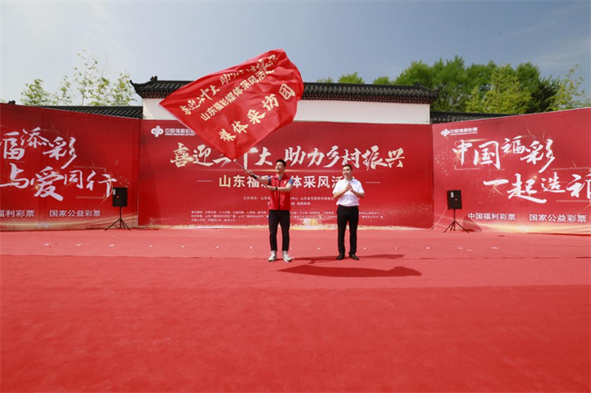 為媒體采風團授旗。 山東省福彩供圖