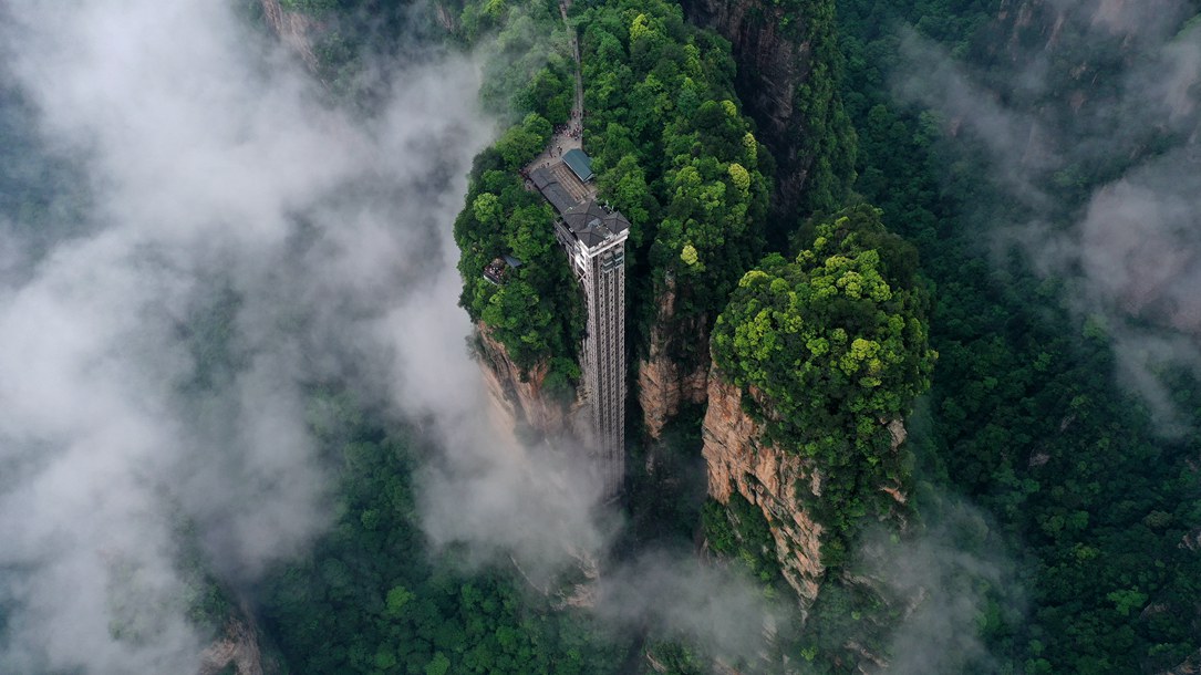 位于張家界武陵源景區(qū)的百龍?zhí)焯蓁偳对谠旗F繚繞的峰林間，雄偉壯觀。吳勇兵攝
