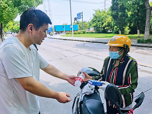 何超為過路的老人送上礦泉水和冷飲。人民網(wǎng)記者 王繼亮攝