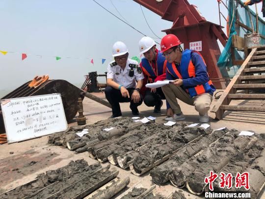 圖為勘察設(shè)計(jì)人員與海事局工作人員查看巖芯情況?！∥赫?攝