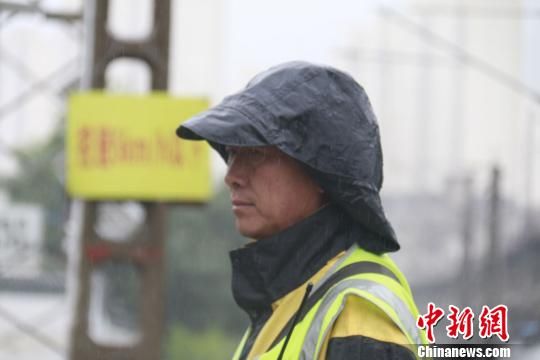 蘭州西工務(wù)段蘭州線路車間防護(hù)員雨中巡查?！⊥豕廨x 攝