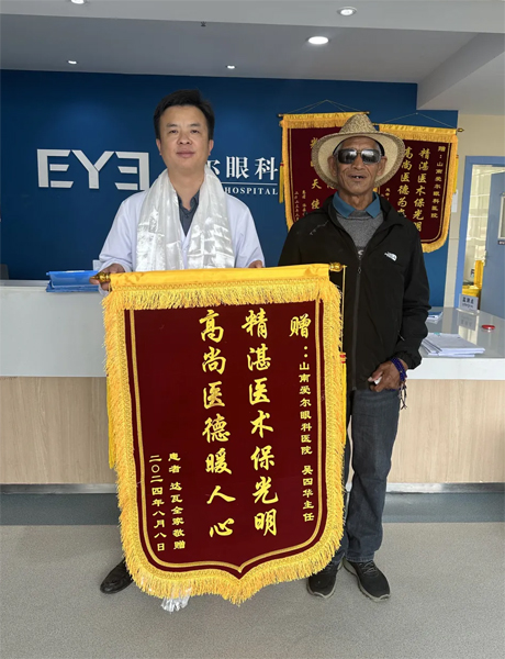 達(dá)瓦老人向吳四華（左）贈(zèng)送錦旗。受訪者供圖