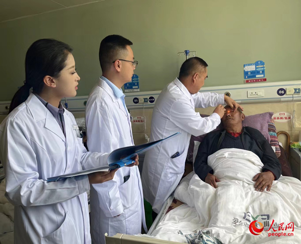 董光明（左三）帶領(lǐng)醫(yī)生對(duì)患者進(jìn)行術(shù)前檢查。人民網(wǎng)記者 杜燕飛攝