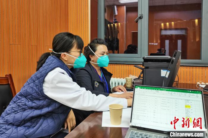 8月9日，楊蘇喬(左)在拉薩方艙醫(yī)院指揮部讀取艙內(nèi)患者胸部CT?！∈茉L者供圖