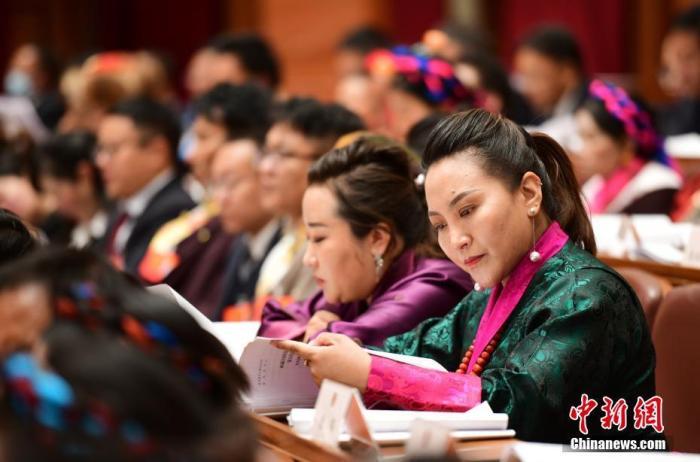 1月5日，次旦卓嘎(右一)在拉薩參加西藏自治區(qū)第十一屆人民代表大會第五次會議第二次全體會議。西藏自治區(qū)人大代表次旦卓嘎來自日喀則市定日縣，定日縣被稱為“洛諧故鄉(xiāng)”，作為西藏民間歌舞，洛諧已被列入中國國家非物質(zhì)文化遺產(chǎn)項目名錄，這是集歌、舞、樂、彈唱于一體的綜合藝術(shù)形式。參加完西藏2022年新年音樂會的次旦卓嘎告訴記者，每年參加的基層演出可達80場，“我希望用最純粹的方式，把最好的聲音帶到西藏乃至中國的各個角落?！?<a target='_blank' href='/'><p  align=