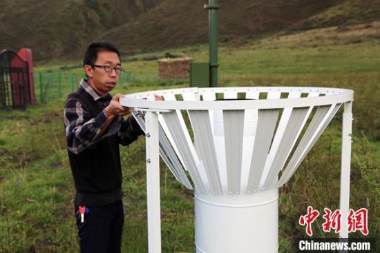 圖為班瑪縣氣象局工作人員在維護(hù)藏雪茶基地氣候站。青海省氣象局供圖