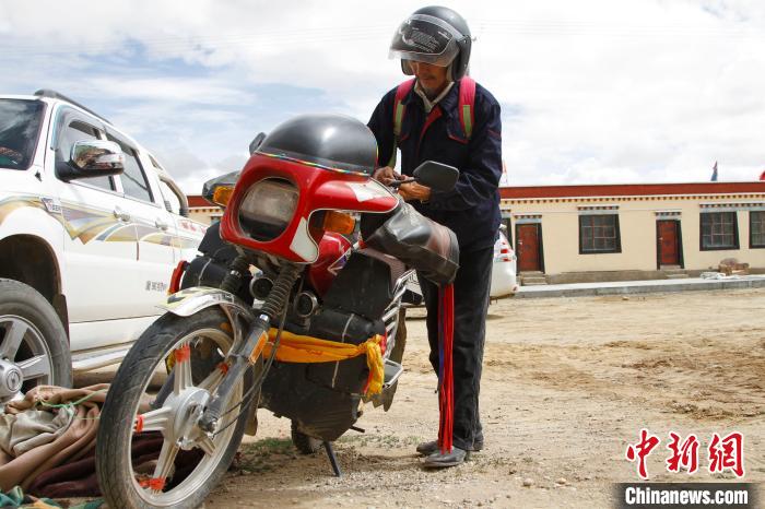 圖為白瑪準備騎摩托車巡湖?！≮w朗 攝