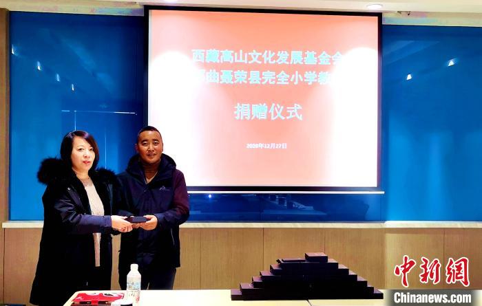 圖為西藏高山文化發(fā)展基金會(huì)理事長(zhǎng)溫麗向聶榮縣完全小學(xué)負(fù)責(zé)人捐助儀器。　于賓 攝