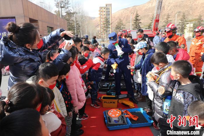 圖為小朋友們聽消防員講解消防器材。　楊龍建 攝