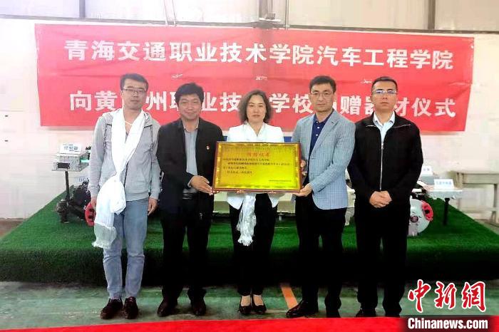 圖為李富香(中)代表學(xué)校為州縣技校捐贈(zèng)器材。(資料圖) 青海省教育廳供圖