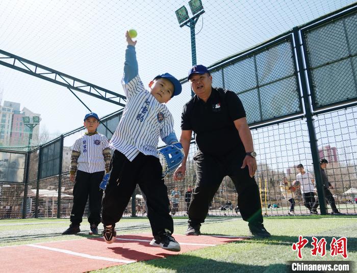 圖為來自臺灣的棒球教練劉興鴻(右)指導(dǎo)小棒球手?jǐn)S球技術(shù)。　馬銘言 攝