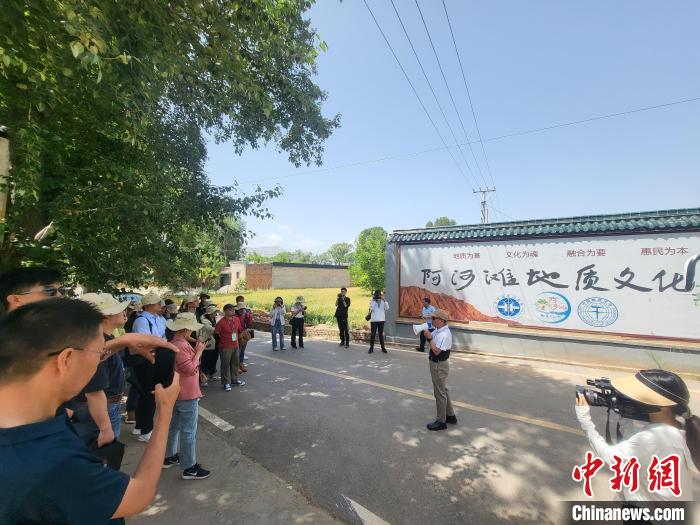 圖為中國地質(zhì)大學(北京)教授張緒教介紹村落情況。　胡友軍 攝