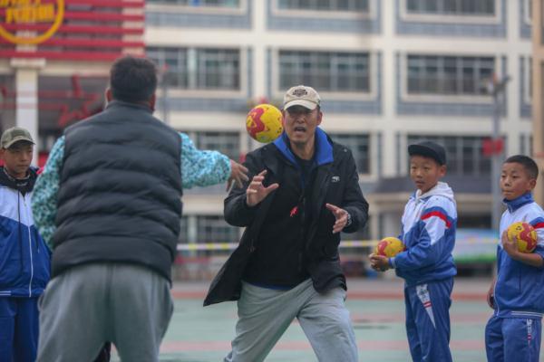 在高原上教孩子們打手球，“慢慢兒來，甭著急！”