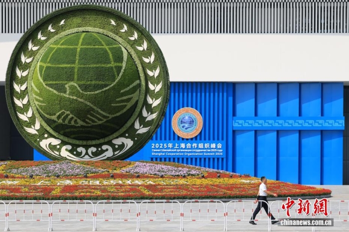 8月31日，天津，一名工作人員從2025年上海合作組織峰會(huì)主會(huì)場(chǎng)外的景觀花壇旁經(jīng)過(guò)。當(dāng)日，2025年上海合作組織峰會(huì)在天津舉行。<a target='_blank' href='/'><p  align=