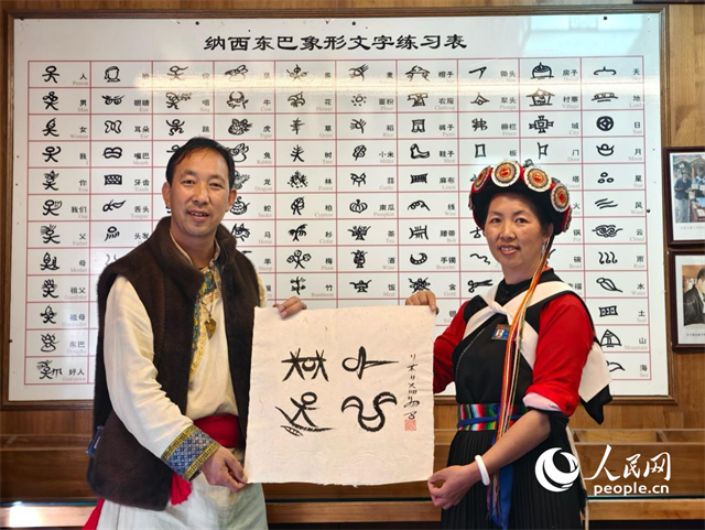 人民網(wǎng)“行進中國”云南調(diào)研采訪團走進麗江，和閏元現(xiàn)場用東巴文寫下“行進中國”。人民網(wǎng)記者 符皓攝