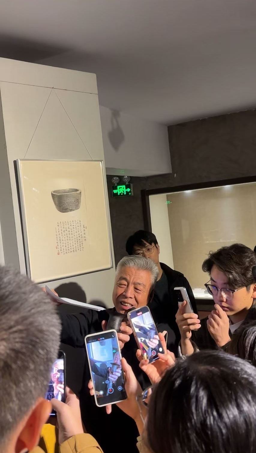 黑陶邢文化博物館館長邢葆東展示兩張相疊的A4紙，向記者解釋此為杯口的厚度。