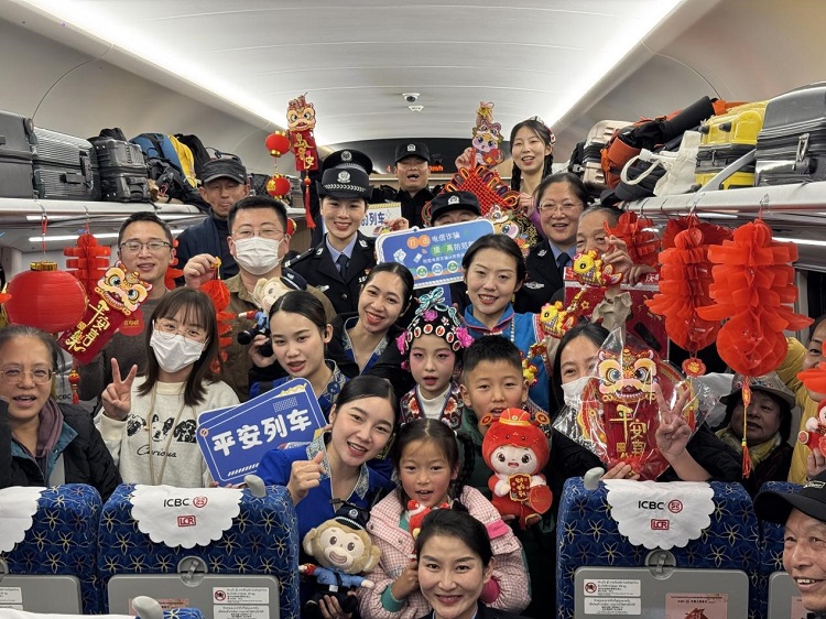 春節(jié)期間，在中老鐵路磨萬（磨丁—萬象）段，鐵路客運員工與乘客合影留念。李加勇攝