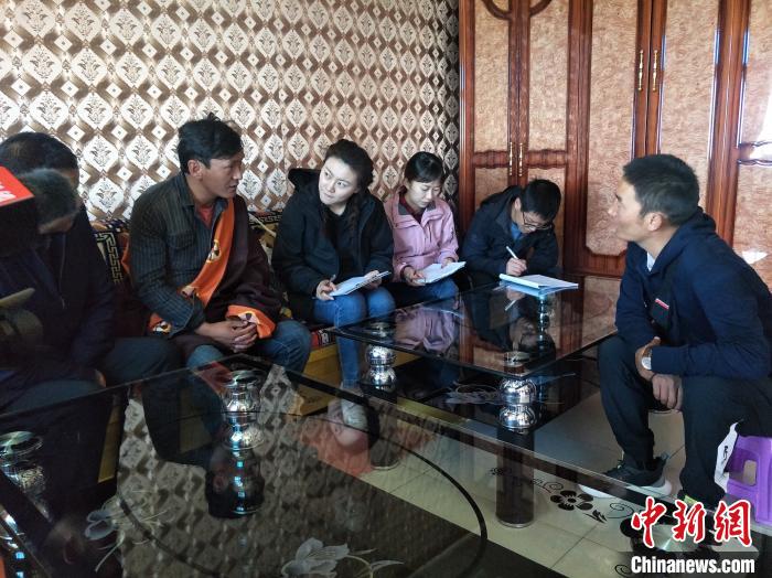 圖為調(diào)查組工作人員正在入戶調(diào)查?！∑钤鲚?攝