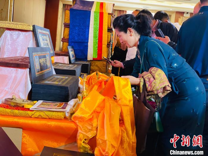 圖為現(xiàn)場藏族民眾向黃金書寫的大藏經(jīng)《甘珠爾》敬獻哈達?！O睿 攝