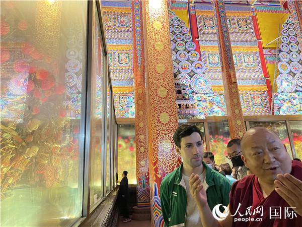 7月25日，省級非物質(zhì)文化遺產(chǎn)項目塔爾寺酥油花的代表性傳承人朋措堅參（右）在塔爾寺酥油花館講解酥油花的制作過程。人民網(wǎng) 謝瑩攝
